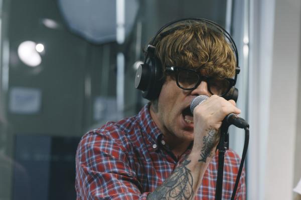 MICHAEL BINGHAM SINGING INTO MICROPHONE AT RADIO STATION